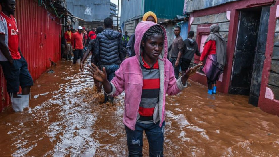 Residents are seen in a flooded street of Mathare neighborhood after heavy rains as they try to evacuate the area with their important belongings in Nairobi, Kenya on April 24, 2024