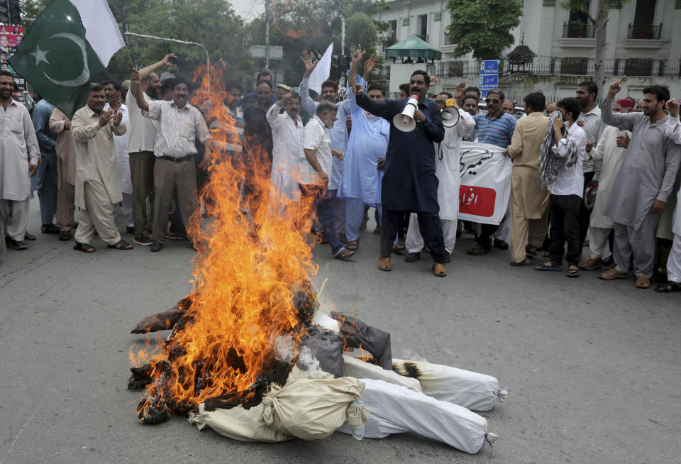 Pakistani clerks shout anti India slogans after burning effigies of Indian Prime Minster Narendra Modi during a protest to express support and solidarity with Indian Kashmiri people in their peaceful struggle for their right to self-determination, in Lahore, Pakistan, Tuesday, Aug. 6, 2019. India's government has revoked disputed Kashmir's special status by a presidential order as thousands of troops patrolled and internet and phone services were suspended in the region where most people oppose Indian rule. (AP Photo/K.M. Chaudary)