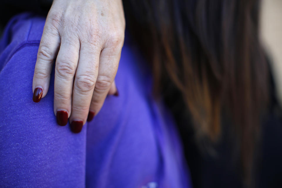 FILE - Adoptive mother Nancy Salminen puts her arm around MJ at their home in Arizona, on Oct. 27, 2021. An Arizona judge has ruled that the Church of Jesus Christ of Latter-day Saints may not use the state's “clergy-penitent privilege” to refuse to answer questions or turn over documents in a child sex-abuse case. (AP Photo/Dario Lopez-Mills, File)