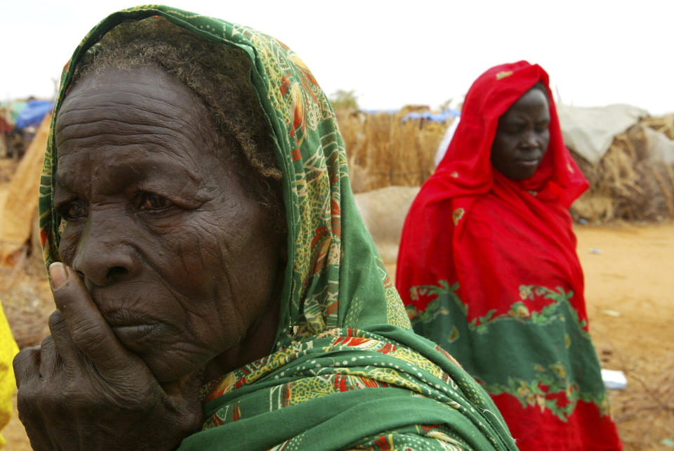 FILE - In this July 1, 2004 file photo, displaced Sudanese women at the Zam Zam refugee camp are seen just outside the town of El-Fashir in the Darfour region of Sudan during a visit by U.N. Secretary General Kofi Annan. Former Sudanese President Omar al-Bashir, driven from power in April 2019, and now languishing in a prison where his opponents were once jailed and tortured, is more vulnerable than ever to a decade-old international arrest warrant for war crimes committed in Darfur. But the military, which forced him from power after four months of mass protests, has said it will not extradite him to the International Criminal Court at the Hague. (AP Photo/Karel Prinsloo, File)