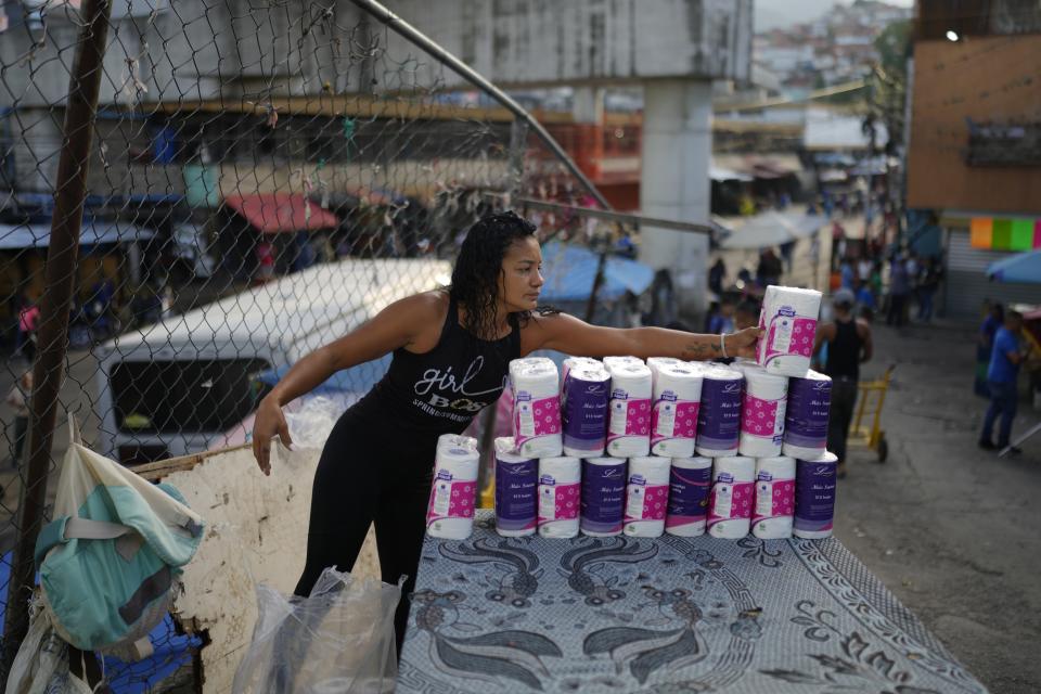 Roisis Lopez pone papel higiénico a la venta en su puesto callejero en el vecindario de Petare, en Caracas, Venezuela, el martes 16 de julio de 2024. (AP Foto/Ariana Cubillos)