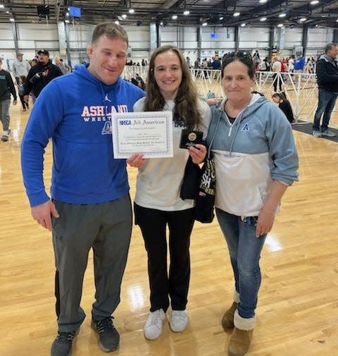 Ashland's Nora Quitt, center, poses with her parents, father Adam, left, and mother Tara after placing third and earning All-America status at the National High School Coaches Association tournament in Virginia Beach on April 7, 2024.