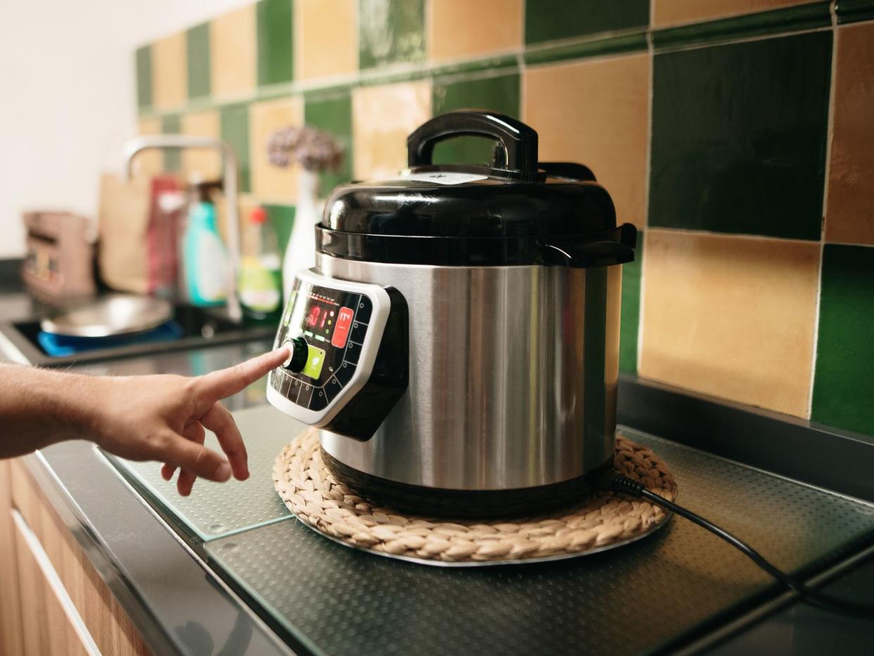 A hand programming an automatic pot