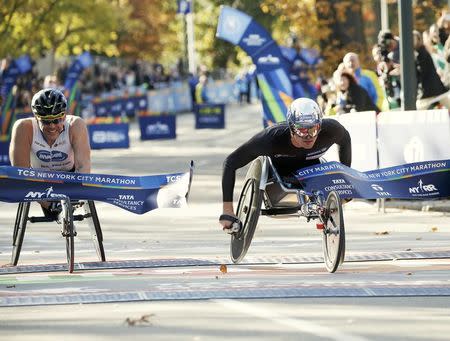 Marcel Hug of Switzerland (R) crosses the finish line ahead of Kurt Fearnley of Australia to win the mens wheelchair division of the 2016 New York City Marathon in Central Park in the Manhattan borough of New York City, New York, U.S. November 6, 2016. REUTERS/Mike Segar