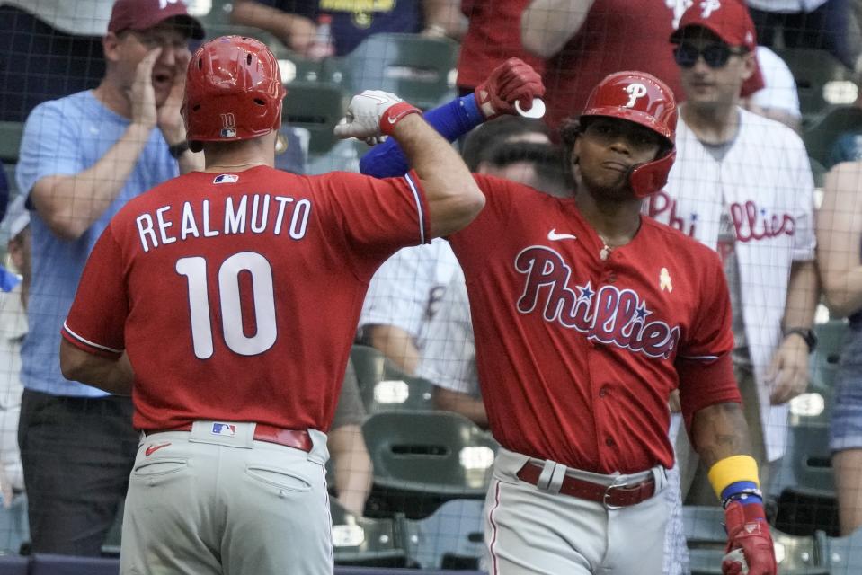 Philadelphia Phillies' J.T. Realmuto is congratulated by Cristian Pache after hitting a home run during the seventh inning of a baseball game against the Milwaukee Brewers Sunday, Sept. 3, 2023, in Milwaukee. (AP Photo/Morry Gash)