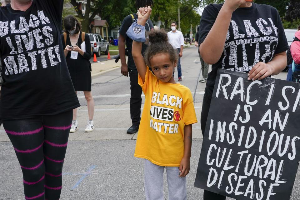 Six-year-old Deja holds her hand in the air during a Black Lives Matter protest Tuesday, Sept. 1, 2020, in Kenosha, Wis. (AP Photo/Morry Gash)