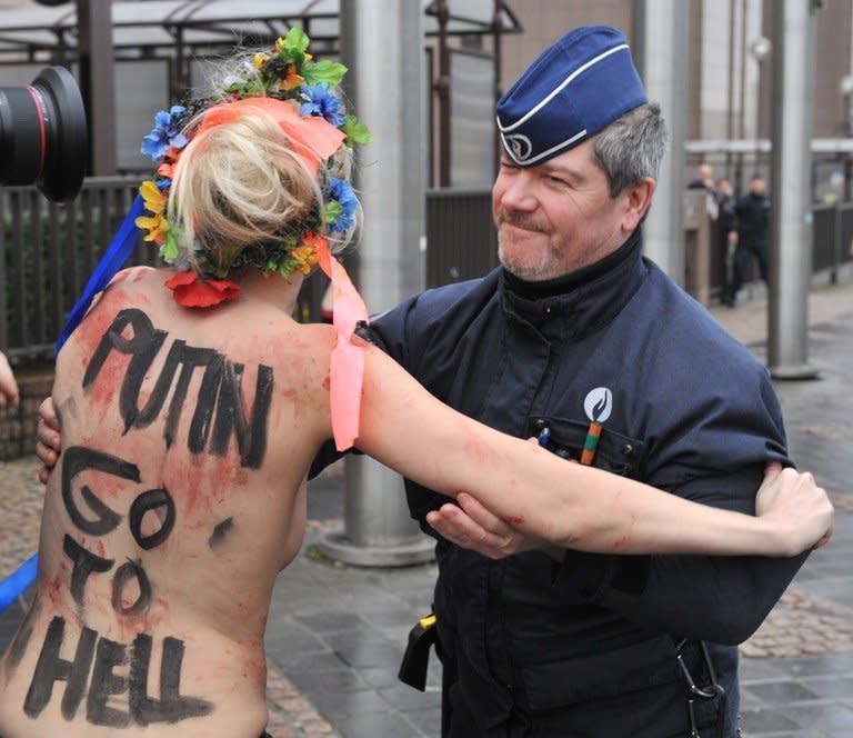 An activist from Femen is taken away by police as she demonstrates against Russian President Vladimir Putin, in Brussels, on December 21, 2012. Some have called the movement a new brand of feminist activism