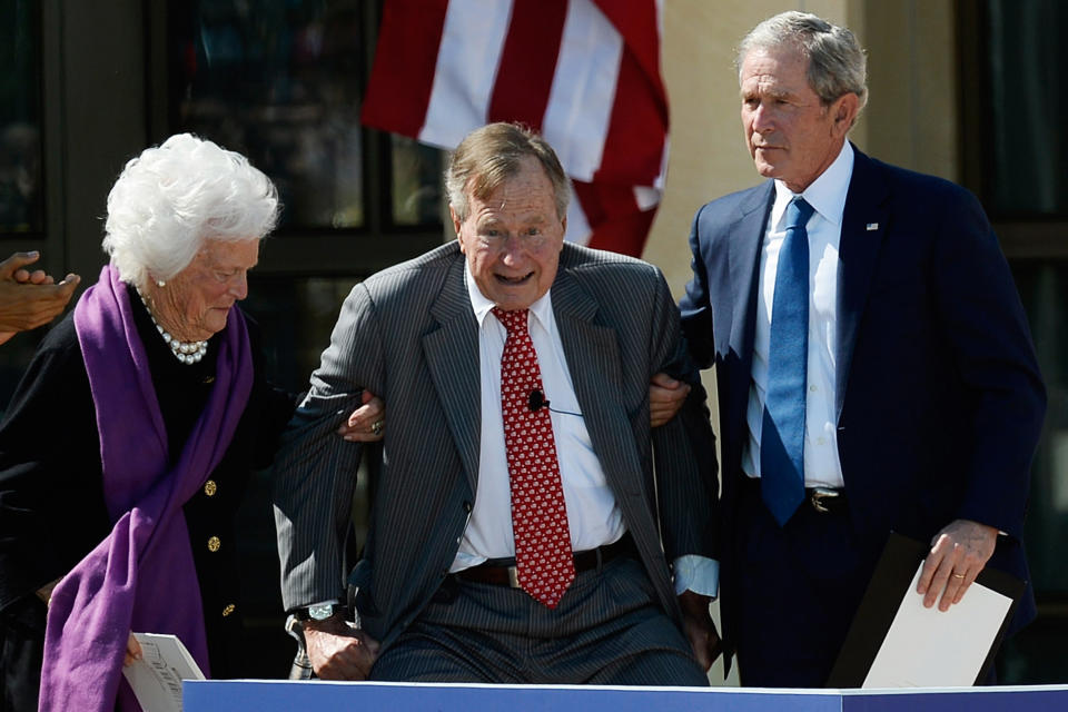 Former first lady Barbara Bush and former President George W. Bush help former President George H.W. Bush rise during the opening ceremony for&nbsp;the George W. Bush Presidential Center on April 25, 2013, in Dallas, Texas.