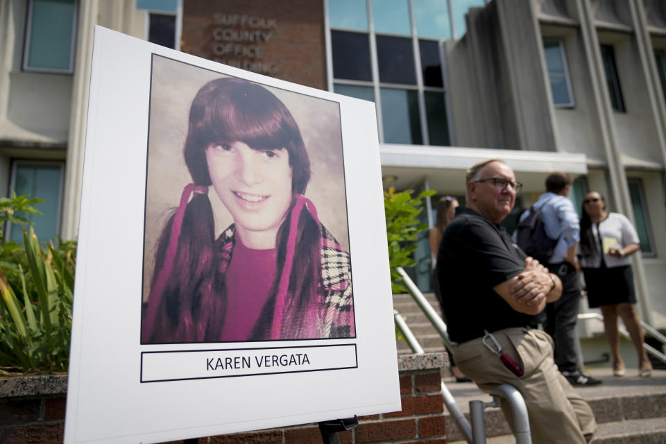 Suffolk County District Attorney Raymond Tierney speaks at a news conference to announce the identity of a victim investigators had called the "Jane Doe No. 7," as Karen Vergata, pictured at left, Friday, Aug. 4, 2023, in Hauppauge, New York. Law enforcement authorities said Friday they have identified a woman whose remains were found as far back as 1996 in different spots along the Long Island coast, some of them near the Gilgo Beach locations of bodies investigators believe were left by a serial killer. (AP Photo/John Minchillo)