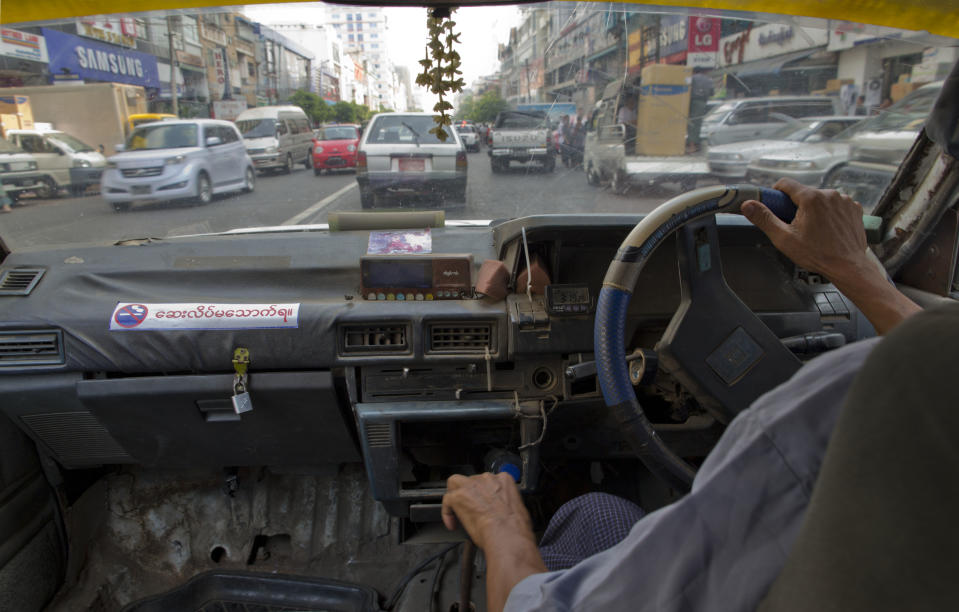 In this April 7, 2014 photo, a taxi driver navigates a 1989 Nissan Trad Sunny, one of few remaining clunkers, through traffic in Yangon, Myanmar. One of the quaintest of many anachronisms in Yangon, a city of moldering colonial villas and gleaming golden pagodas, used to be the decades old Toyotas, Chevys and other clunkers wheezing down its mostly empty roads, a visible sign of sanctions and economic isolation. Now, the streets have filled with a flood of newer used cars, mostly from Japan. (AP Photo/Gemunu Amarasinghe)