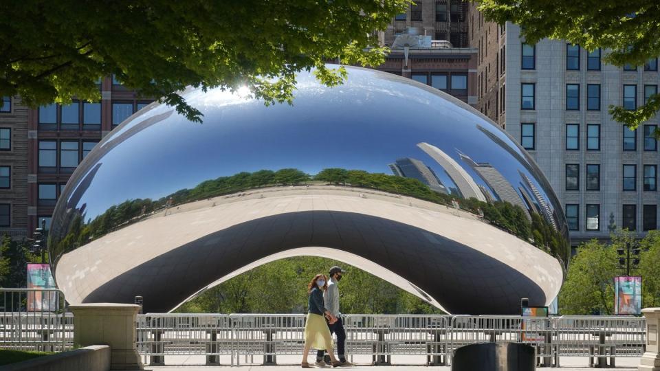 Visitors walk past the Cloud Gate sculpture in Millennium Park