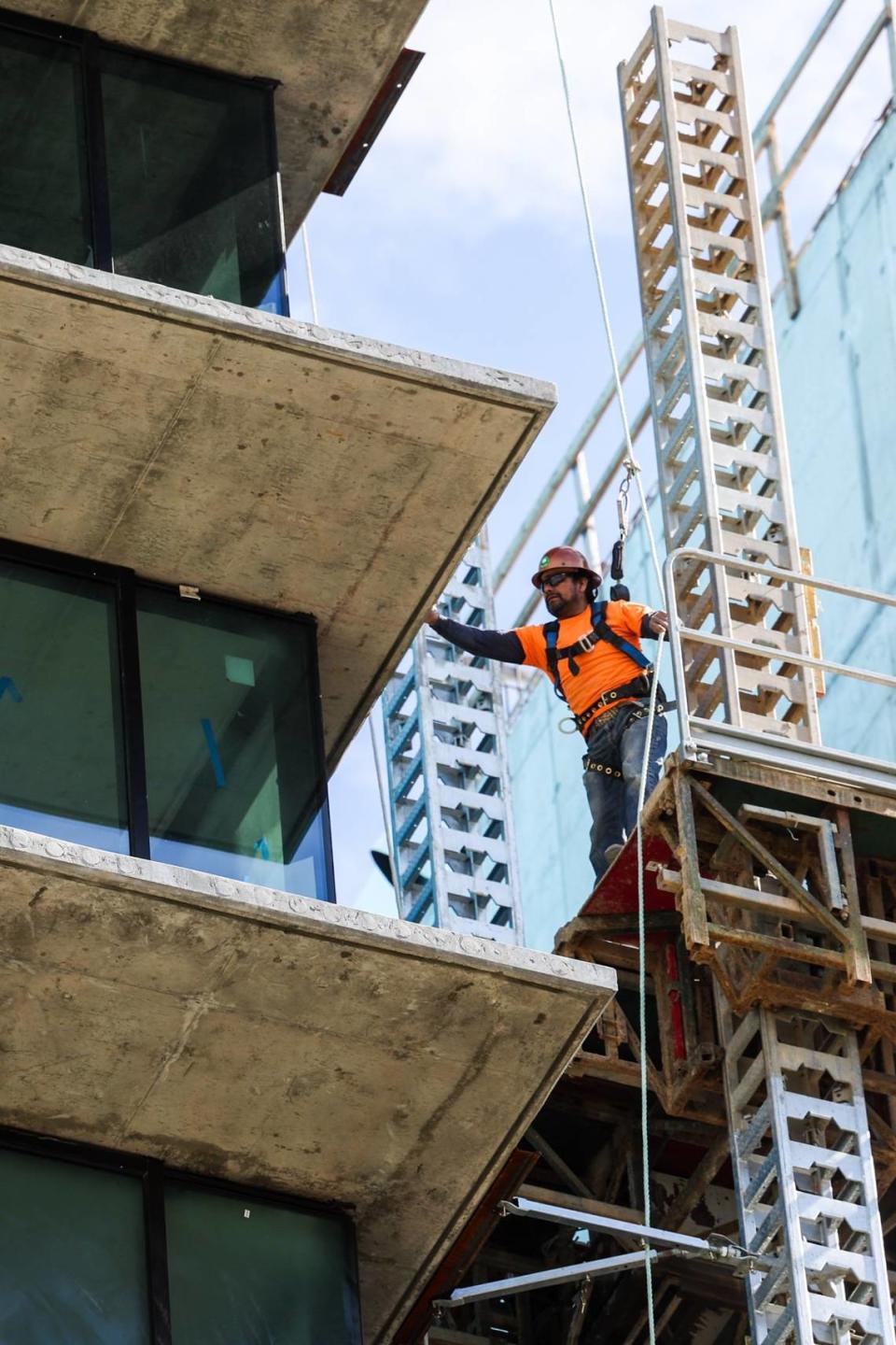 A worker wears the appropriate fall protection while working several floors above the ground at a residential tower under construction on East Morehead Street. A scaffolding collapse on Jan. 2, 2023 killed three workers at the construction site.