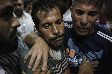 Relatives of Palestinians, whom medics said were killed in Israeli shelling at a U.N-run school sheltering Palestinian refugees, mourn outside a hospital morgue in the northern Gaza Strip July 24, 2014. REUTERS/Finbarr O'Reilly