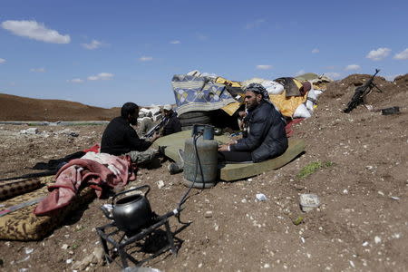 Rebel fighters from 'Jaysh al-Sunna' sit on a look-out point in Tel Mamo village, in the southern countryside of Aleppo, Syria March 6, 2016. REUTERS/Khalil Ashawi