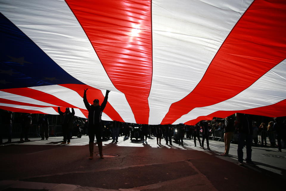 <p>An American flag is draped across Fifth Avenue during the Veterans Day parade in New York on Nov. 11, 2017. (Photo: Gordon Donovan/Yahoo News) </p>