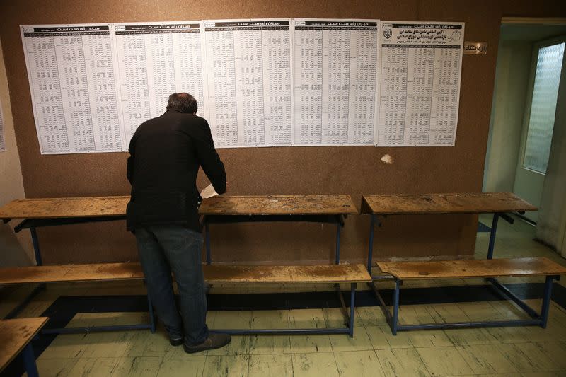 An Iranian checks the names of candidates during parliamentary elections at a polling station in Tehran