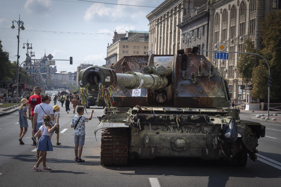 People visit an avenue where destroyed Russian military vehicles have been displayed ahead of the Independence Day in Kyiv, Ukraine, Monday, Aug. 21, 2023. Ukraine marks the Independence Day on Aug. 24. (AP Photo/Efrem Lukatsky)