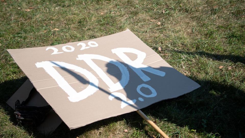 Ein Schild mit der Aufschrift «2020 DDR 2.0» liegt während einer Kundgebung der Initiative «Querdenken 711» im Stuttgarter Schlossgarten.