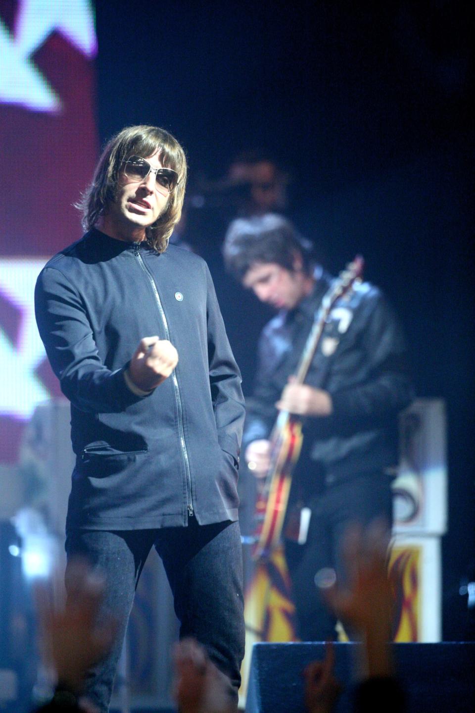 UNITED KINGDOM - FEBRUARY 14:  BRIT AWARDS  Photo of Liam GALLAGHER and OASIS, Liam Gallagher & Noel Gallagher (b'ground) performing live onstage during the finale of the 2007 Brit Awards at Earls Court  (Photo by JMEnternational/Redferns)