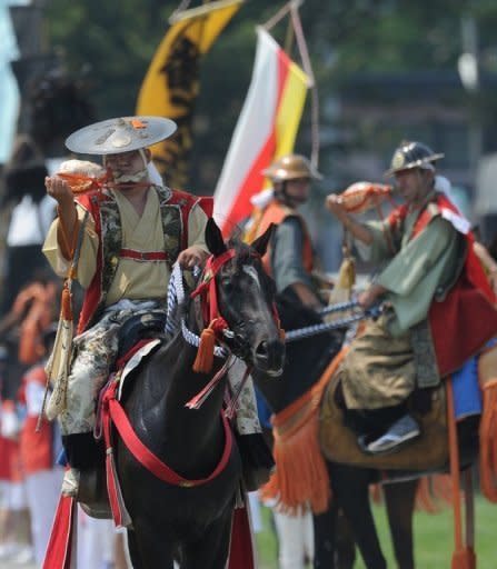 People clad in samurai costumes play the triton on horseback during a parade at the annual Soma Nomaoi festival in Minamisoma. Clad in decorated helmets and carrying traditional Japanese swords, participants swaggered about on horseback followed by a feudal lord's procession decorated with colourful banners displaying their family crests