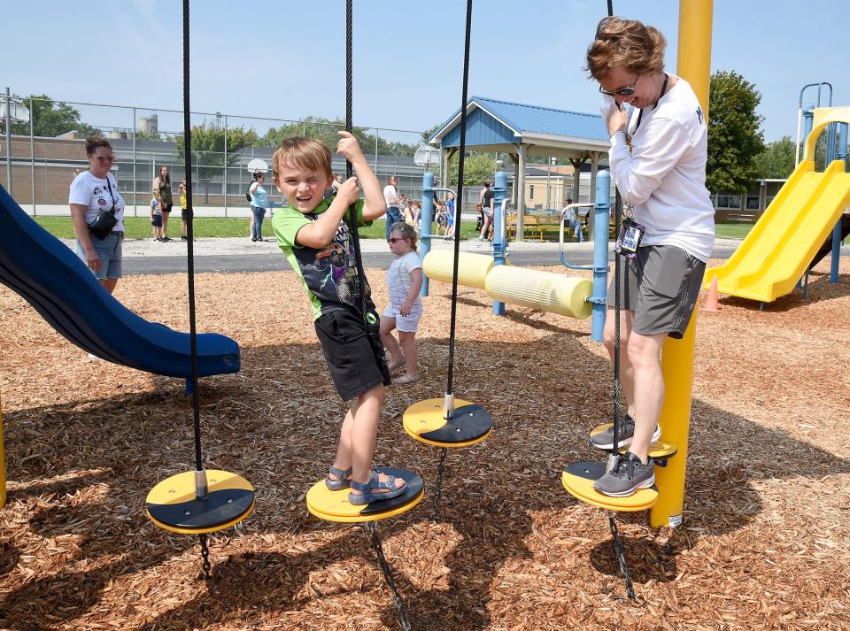 Ida Elementary principal Stacy Maynard plays with new kindergartner Corbin Bean, 5, on the school's playground as part of 2023 Playdates with Principals hosted by the Monroe County Intermediate School District and Great Start Collaborative of Monroe County. Behind him is twin sister Payton, 5, and mother Stephanie Bean.