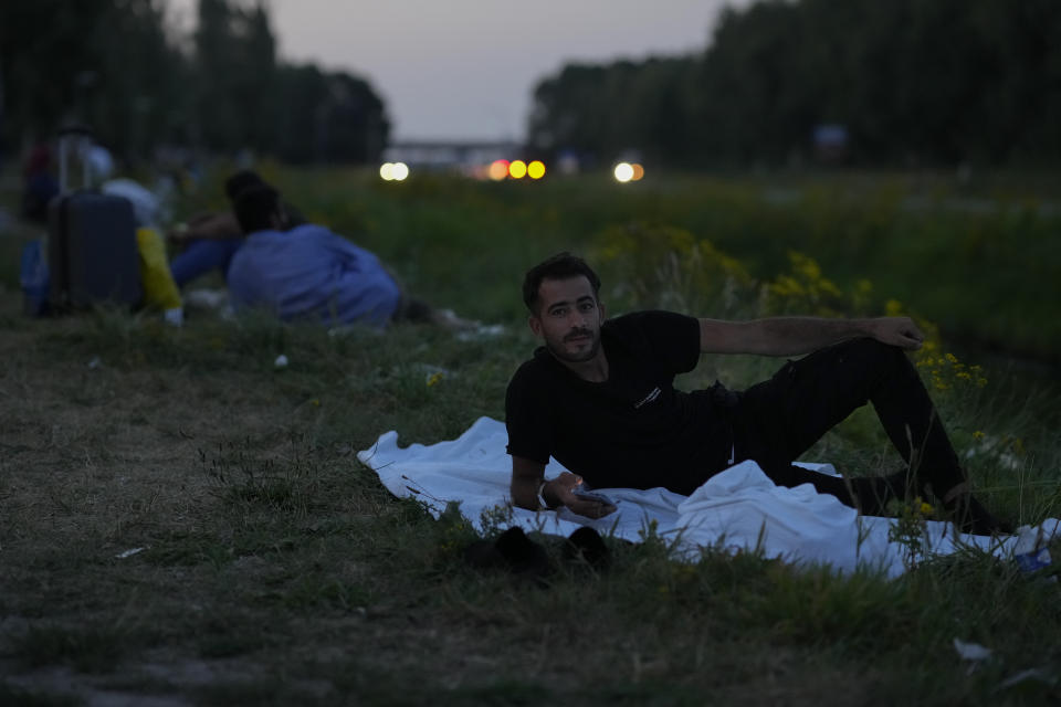 Hundreds of migrants who seek shelter prepare to sleep outside an overcrowded asylum seekers center in Ter Apel, northern Netherlands, Thursday, Aug. 25, 2022. (AP Photo/Peter Dejong)