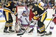 Pittsburgh Penguins' Sidney Crosby (87) tries to control the puck in front of New York Rangers goaltender Igor Shesterkin (31) as Penguins' Bryan Rust (17) watches during the second period of an NHL hockey game, Saturday, Feb. 26, 2022, in Pittsburgh. (AP Photo/Keith Srakocic)