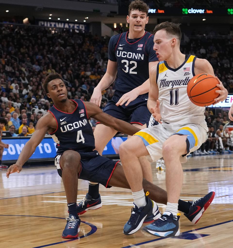 Marquette guard Tyler Kolek (11) runs into Connecticut guard Nahiem Alleyne (4) during the first half of their game Wednesday, January 11, 2023 at Fiserv Forum in Milwaukee, Wis.