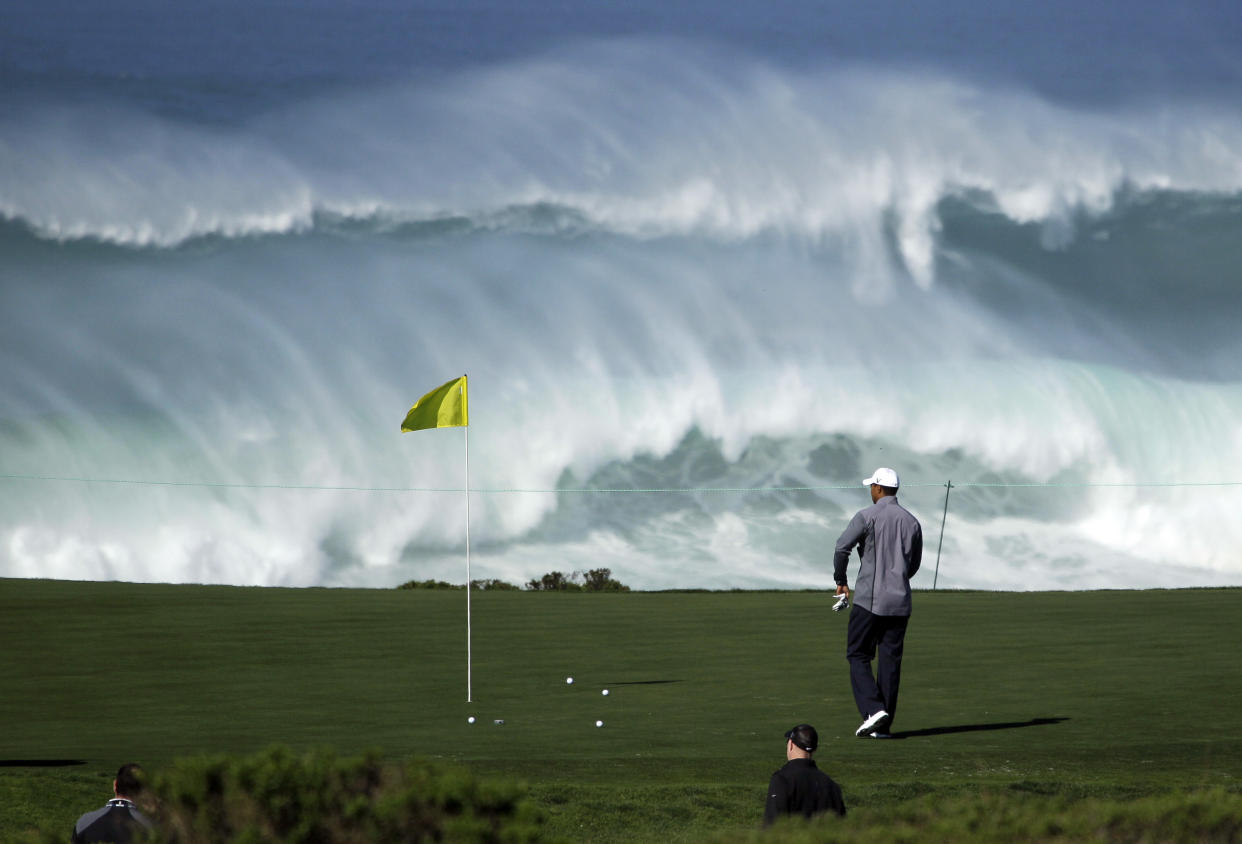 Tiger Woods walks to his ball on the 15th green of the Monterey Peninsula Country Club shore course as waves crash in the background during a practice round at the AT&T Pebble Beach National Pro-Am PGA Tour golf tournament in Pebble Beach, Calif., Wednesday, Feb. 8, 2012. (AP Photo/Eric Risberg)