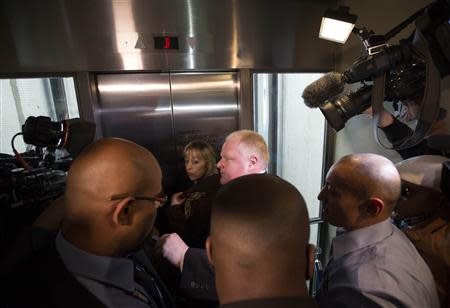Toronto Mayor Rob Ford leaves a news conference with his wife Renata (C) through a crush of reporters at City Hall in Toronto, November 14, 2013. REUTERS/Mark Blinch