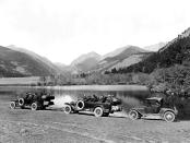 <p>A line of Rocky Mountain tour cars take the scenic route around a Colorado lake.</p>