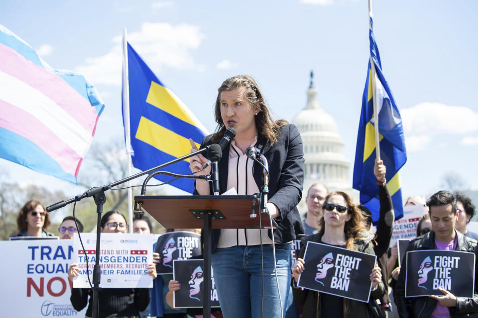 Charlotte Clymer stands at a podium during a rally.