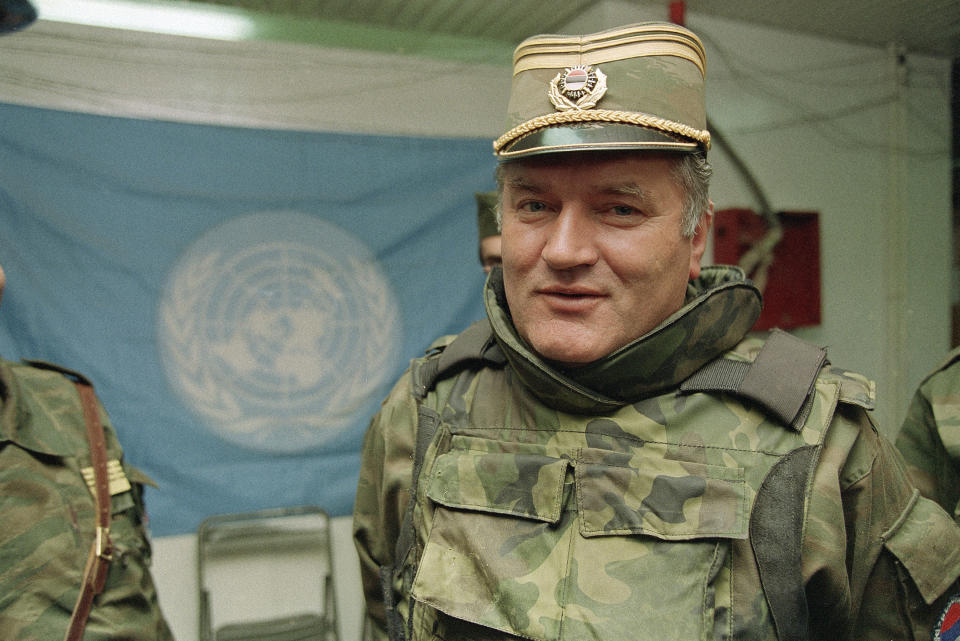 FILE - In this May 17, 1993 file photo, Bosnian Serb commander Gen. Ratko Mladic is pictured near a United Nations flag at Sarajevo Airport. U.N. judges will on Tuesday, June 8, 2021 deliver their final ruling on the conviction of former Bosnian Serb army chief Ratko Mladic on charges of genocide, war crimes and crimes against humanity during Bosnia's 1992-95 ethnic carnage. (AP Photo/Jerome Delay, File)