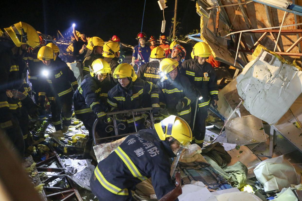 In this photo released by China's Xinhua News Agency, emergency personnel search through the wreckage of buildings destroyed by a reported tornado in Wuhan early Saturday.