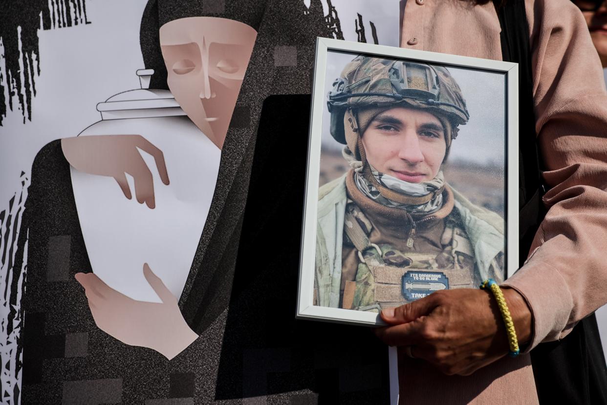 Relatives hold portaits of killed Ukrainian servicemn as they rally for the creation of a national military cemetery at Independence Square in Kyiv. (EPA)