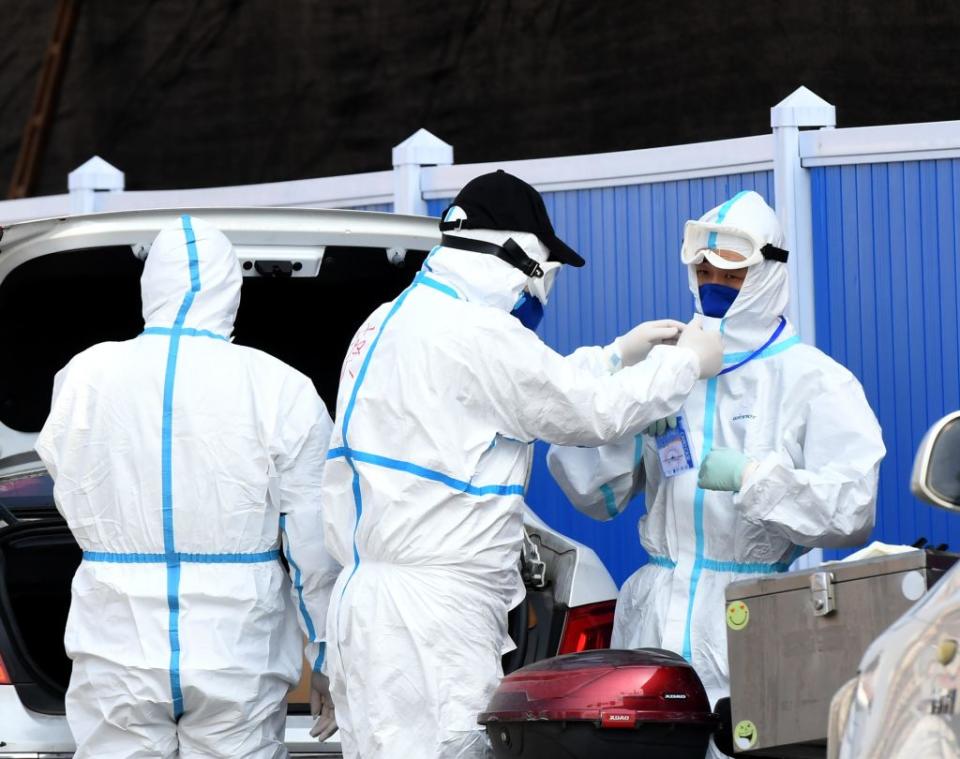 People wear protective masks and suits for disinfection work at Huanan Wholesale Seafood Market.