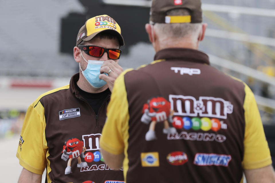 Crew members for driver Kyle Busch talk in pit row before the NASCAR Cup Series auto race Sunday, May 17, 2020, in Darlington, S.C. (AP Photo/Brynn Anderson)