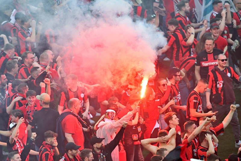 Leverkusen fans cheer with pyrotechnics on the pitch to celebrate winning the German championship following the German Bundesliga soccer match between Bayer 04 Leverkusen and SV Werder Bremen at BayArena. David Inderlied/dpa