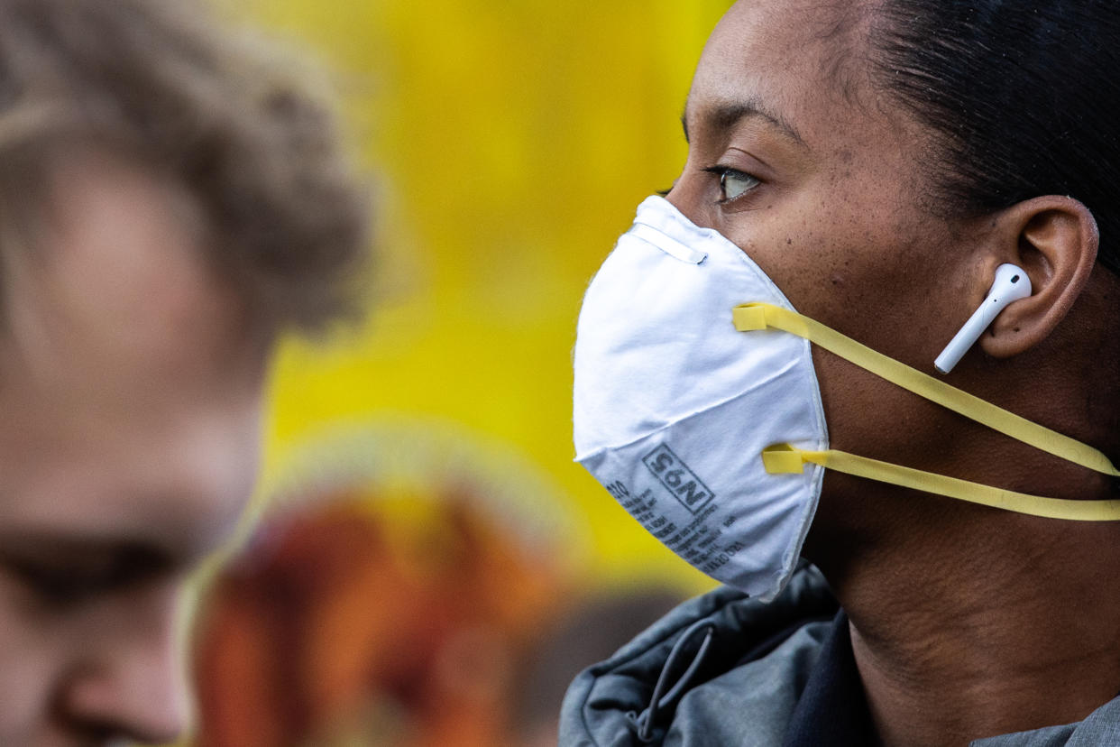 A new report from the CDC suggests the coronavirus may be spread before the onset of symptoms. Here a woman wearing a protective mask is seen in New York. (Photo by Jeenah Moon/Getty Images)