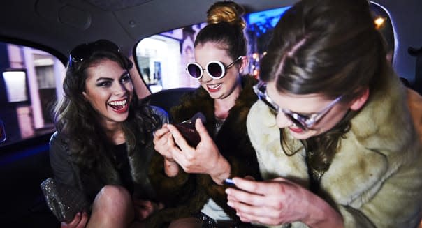 Women laughing together in taxi