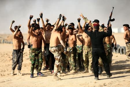 Sunni volunteers, who have joined the Abbas Fighting Division, shout slogans after a field training in Kerbala, Iraq December 20, 2017. REUTERS/Thaier Al-Sudani
