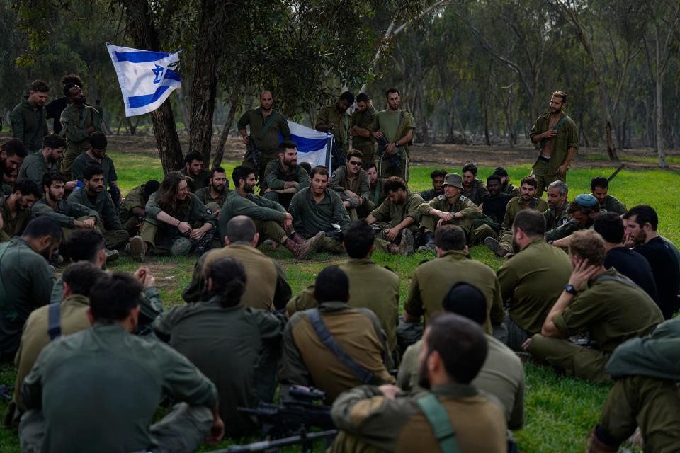 Israeli soldiers are briefed after coming back from the Gaza Strip at a staging area in southern Israel on Dec. 17, 2023.