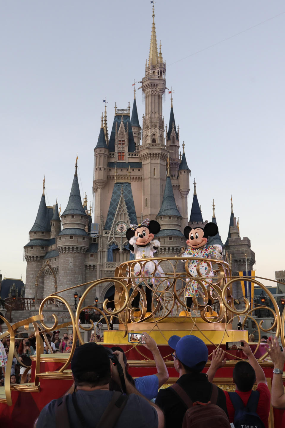 FILE - In this Wednesday, Jan. 15, 2020 photo, Mickey and Minnie Mouse perform during a parade as they pass by the Cinderella Castle at the Magic Kingdom theme park at Walt Disney World in Lake Buena Vista, Fla. Tens of thousands of LGBTQ+ people are flocking to Florida's theme parks and hotels to go on thrill rides, dance at all-night parties and lounge poolside in a decades-long tradition known as “Gay Days.” Even though Gov. Ron DeSantis and Florida lawmakers have championed a slew of anti-LGBTQ laws, that’s not stopping organizers from encouraging visitors from around the world to come and visit. (AP Photo/John Raoux, File)