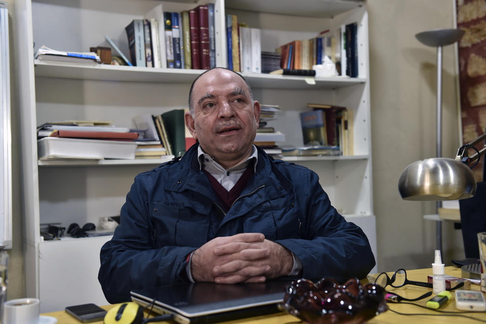 This photo provided by Monika Borgmann shows her husband, Lokman Slim, a well-known Lebanese publisher and vocal critic of Hezbollah, the Lebanese Shiite Muslim group, at his desk in the southern Beirut suburb of Dahiyeh, Lebanon, Jan. 5, 2017. Slim was killed Thursday, Feb. 4, 2021. Borgmann said she is discussing with lawyers and friends how to push for an international investigation into her husband's murder. (Lokman Slim family via AP)