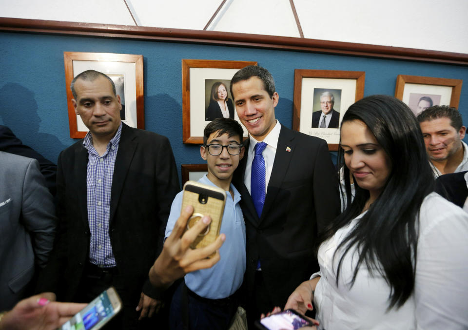 Venezuela's opposition leader and self-proclaimed interim president Juan Guaidó poses for a photo with a supporter at the end of a meeting with the Chamber of Commerce, in Caracas, Venezuela, Thursday, May 16, 2019. Guaidó referred to the Norwegian initiative, efforts to mediate between the opposition and the government of President Nicolás Maduro, in remarks on Thursday, but said the opposition won't enter into any "false negotiation." (AP Photo/Fernando Llano)
