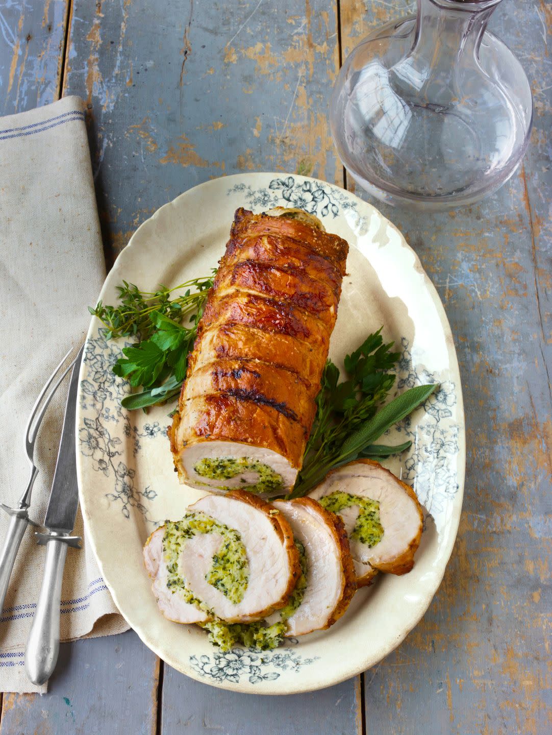 roast pork loin with herb stuffing on an oval serving plate with a few slices cut at one end