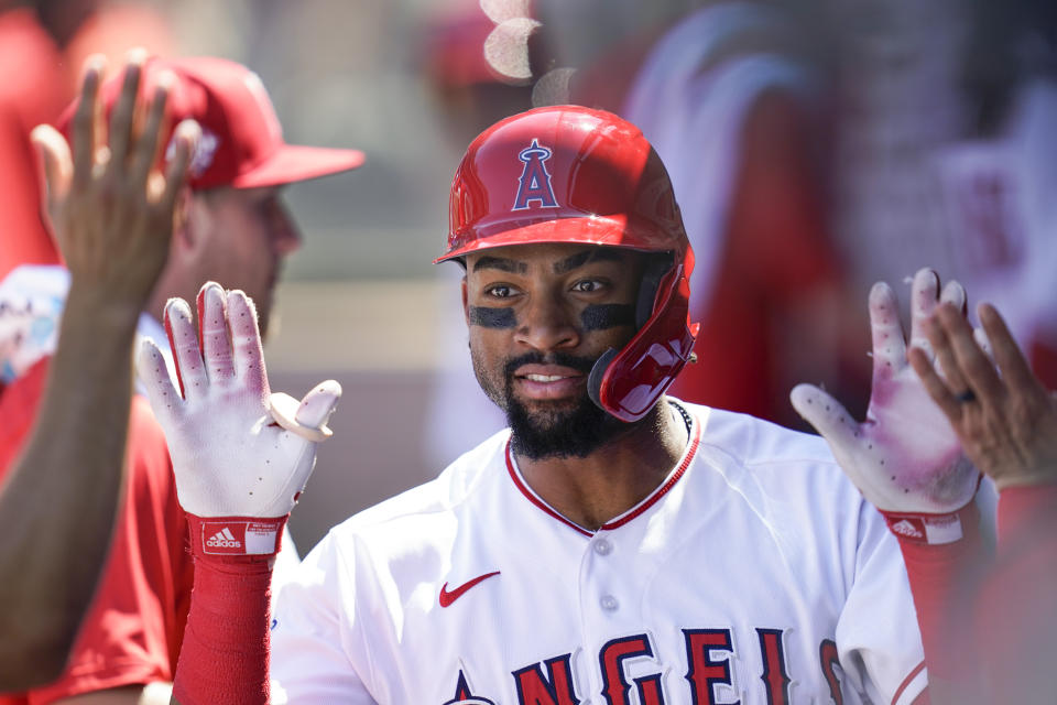 Los Angeles Angels' Jo Adell, left, celebrates in the dugout after hitting a home run during the fourth inning of a baseball game against the Texas Rangers Sunday, Sept. 5, 2021, in Anaheim, Calif. (AP Photo/Ashley Landis)