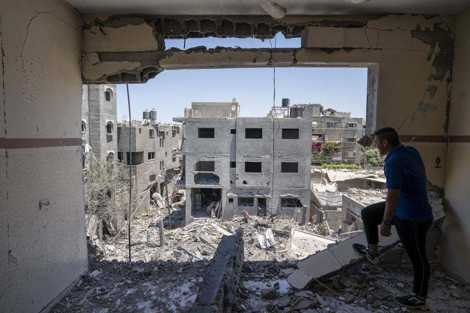 Neighbors walk through a severely damaged home after a neighboring building was destroyed by an airstrike in Magazzi, the Gaza Strip. (John Minchillo/AP)