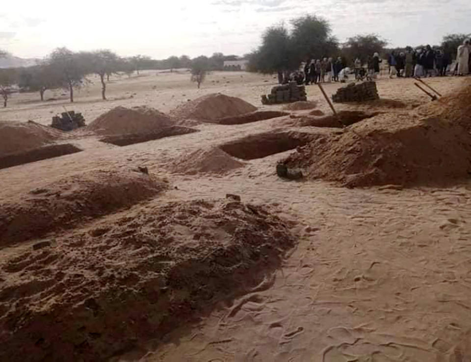 People gather as victims from a collapsed gold mine are buried on Tuesday, Dec. 28, 2021 in Kordofan, Sudan. The defunct mine collapsed earlier this week, killing several people. The Sudanese Mineral Resources Limited Company said the mine was not functional but local miners returned to work there after security forces guarding the site left the area. (Sudanese Mineral Resources Limited Company via AP)