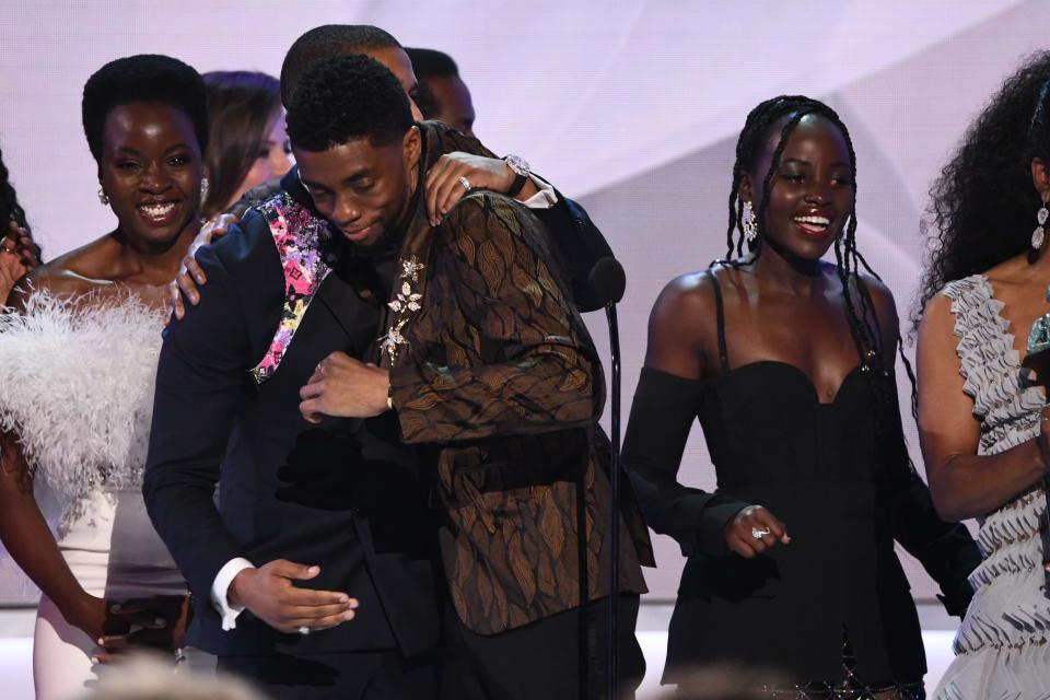 Michael B. Jordan (L) congratulates Chadwick Boseman (C)  as the cast of “Black Panther” accepts an award at  the 25th Annual Screen Actors Guild Awards on Jan 27, 2019.